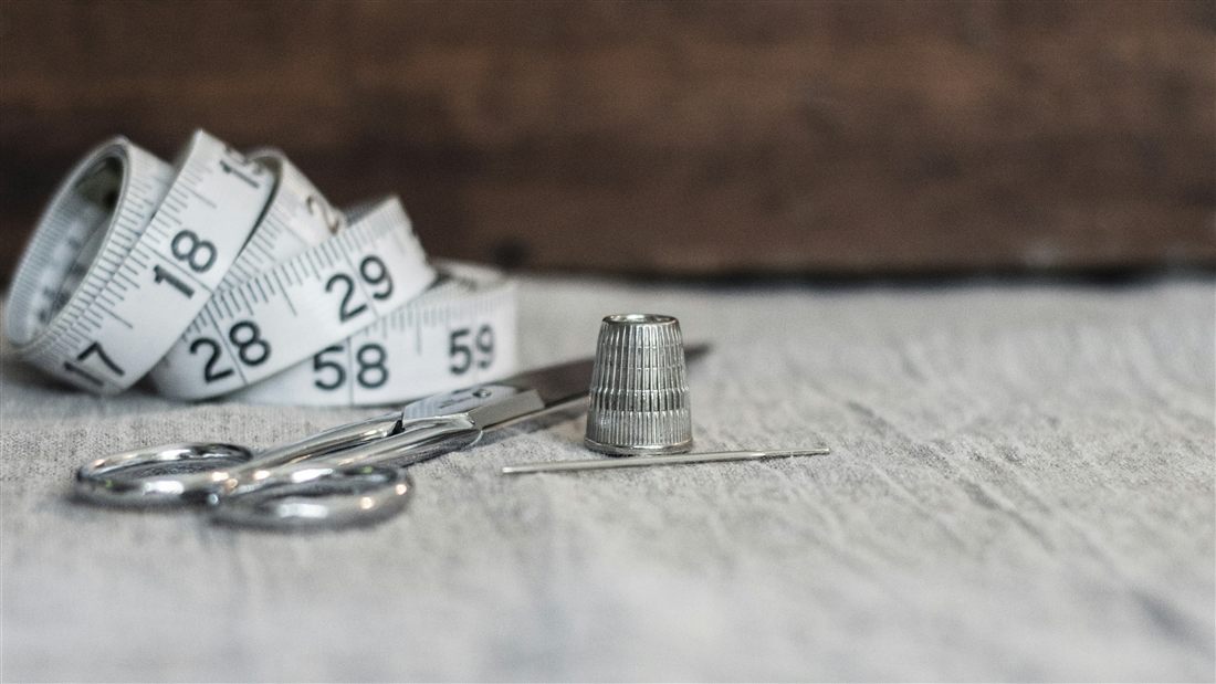 Fita métrica, tesoura, dedal e agulha — ferramentas do ateliê